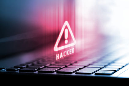 Ein rotes Warnschild "System hacked" schwebt über einer Tastatur
