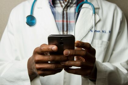 Ein Arzt mit einem Handy in der Hand